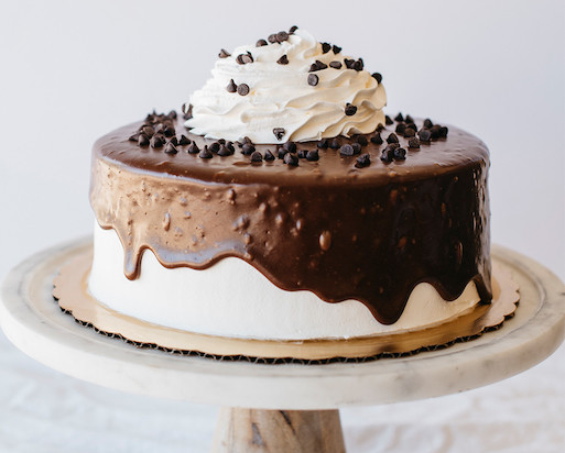 a chocolate cake with a white frosting and chocolate sprinkles